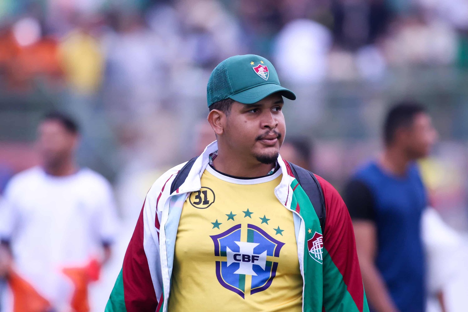 Samuel Moraes em campo com boné e camisa do Fluminense de Feira durante cobertura de jogo